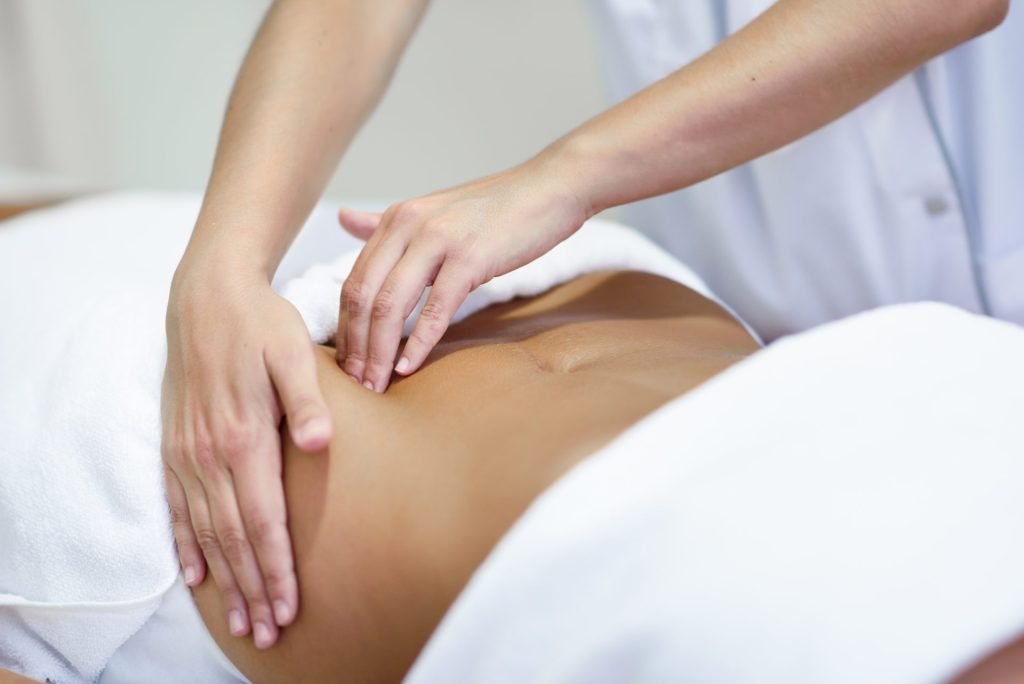 mujer que recibe un masaje del vientre en el spa